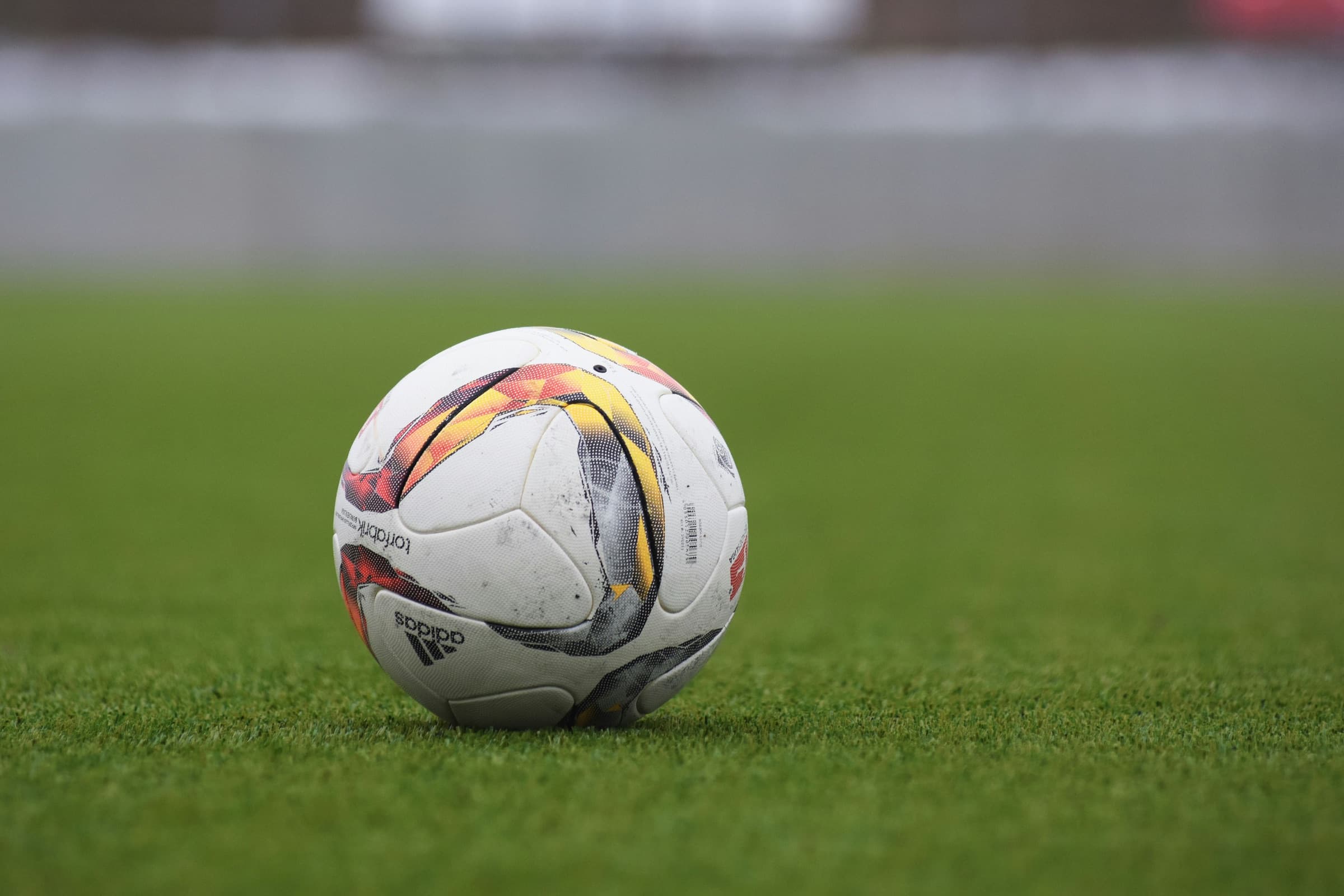 A well-worn soccer ball on a grass field
